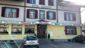 Restaurant von Aussen mit Parkplatz für Autos